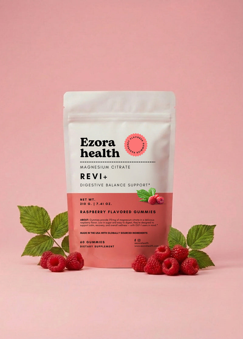 Ezora Health Revi+ Magnesium Citrate gummies pouch on a soft pink background with fresh raspberries
